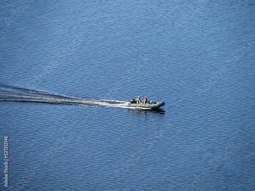 Ukraine-Russian conflict. Special forces men in camouflage uniforms on army motorboat. Boat moving across the river in the morning, diversionary mission,copy space. Military on an inflatable boat. photo