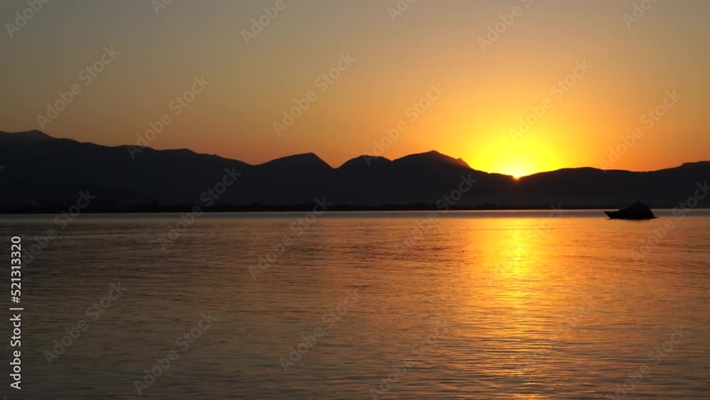 Sunrise on the horizon with mountain and boat. Finike, Antalya, Turkey Sunrise on the horizon with mountain and boat. Finike, Antalya, Turkey