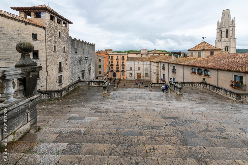 View from the top of the steps at the Girona Cathedral of Saint Mary looking down over the Jewish Quarter and medieval village streets and alleys of Girona, Spain.