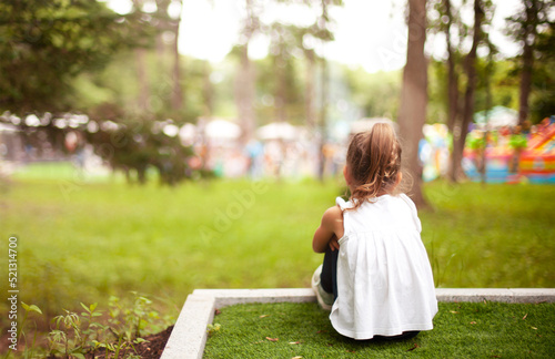 a lonely little girl from afar is looking at a crowded event