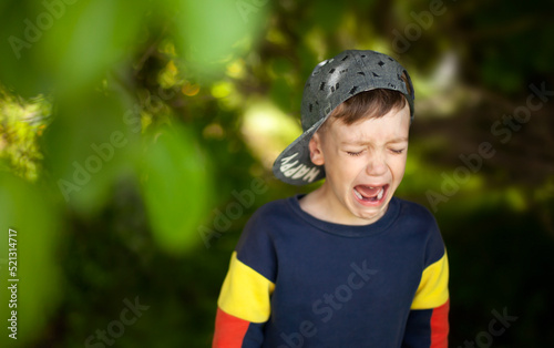Obraz na płótnie the boy is crying loudly in the shade of the trees