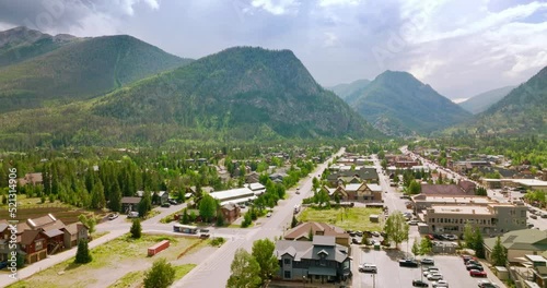 Lovely town with numerous cottages beside pine trees. Amazing view of a city at the backdrop of gorgeous mountains in Colorado, USA. photo