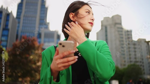 portrait of pretty korean woman in urban landscape, asian lady with smartphone in big city