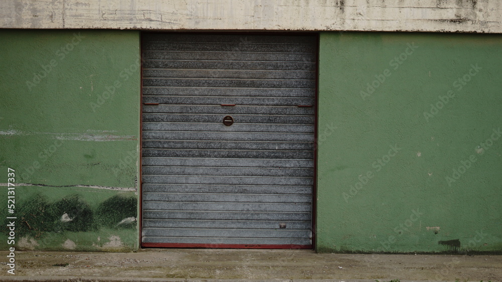 garage metal door on green facade garage metal door on green facade