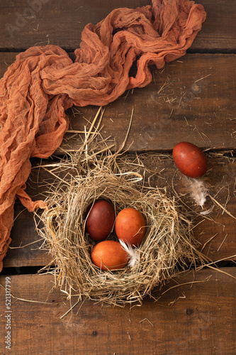 Painted Easter chicken eggs in a nest and willow branches. Holiday Easter concept background. High quality photo