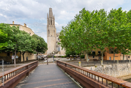View from the Sant Feliu Pedestrian Bridge over the River Onyar of the tower of the Church of Saint Felix or Basilica de Sant Feliu, above the medieval old town of Girona, Spain. photo