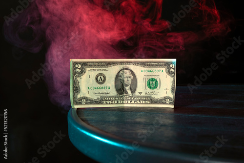 Banknote two dollars of the united states of america on the table background of red smoke , symbol