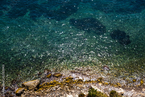 View of the transparent water of the sea on the coast from the rocky cliffs, natural background.
