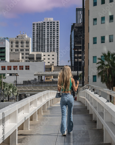 young woman loose hair blonde walking on the bridge miami Brickell downtown building sky lifestyle 