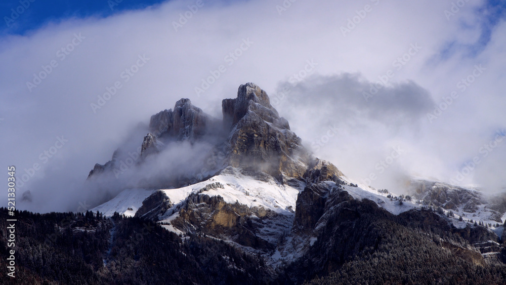 Blue sky and white clouds on snowy mountain peak in the French Alps