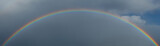 Rainbow against the disturbing sky after the rain