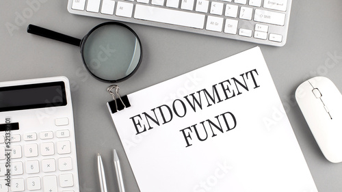 ENDOWMENT FUND written on paper with office tools and keyboard on the grey background