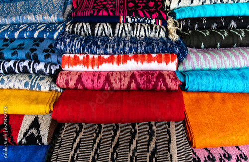 Scarves or Macanas at the market, traditional handcraft and design for Gualaceo canton, Azuay province, made by using technique called Ikat, colorful fabrics background. Cuenca, Ecuador	 photo