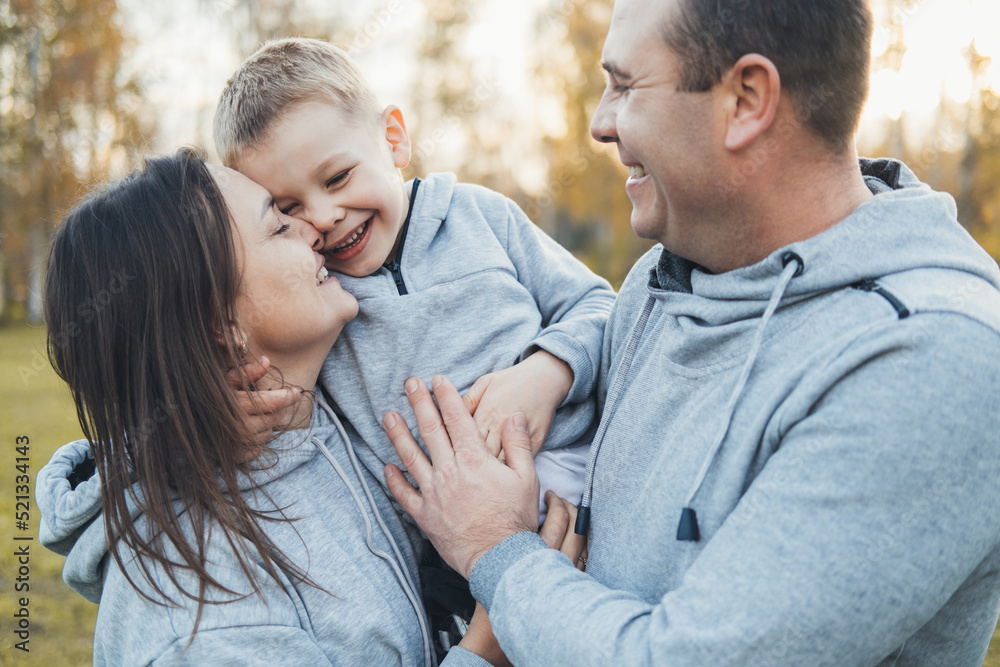 Portrait of a caucasian parents showing affection by hugging and kissing their son. Close up portrait. Happy family, childhood. Portrait of a caucasian parents showing affection by hugging and kissing their son. Close up portrait. Happy family, childhood.