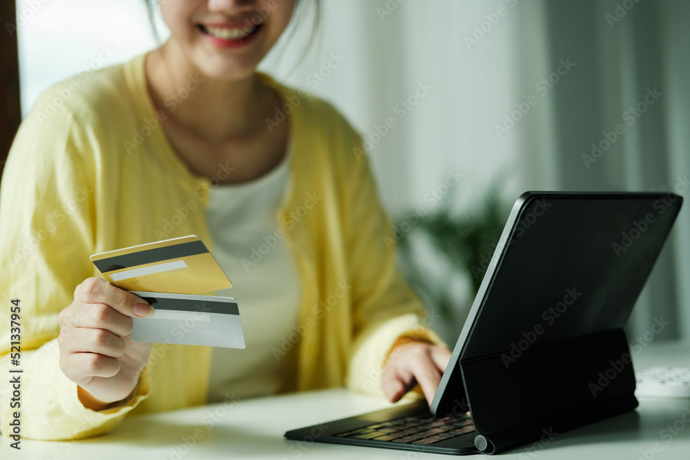 Asian woman using laptop and credit card for online shopping. Asian woman using laptop and credit card for online shopping.