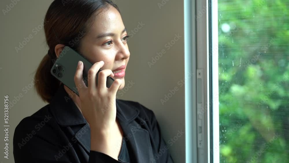 Businesswoman talking on smartphone with windows light