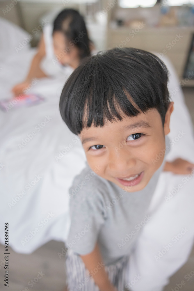 Close-up of smiling little asian boy look in camera wear grey clothes. Portrait of happy cute boy Close-up of smiling little asian boy look in camera wear grey clothes. Portrait of happy cute boy