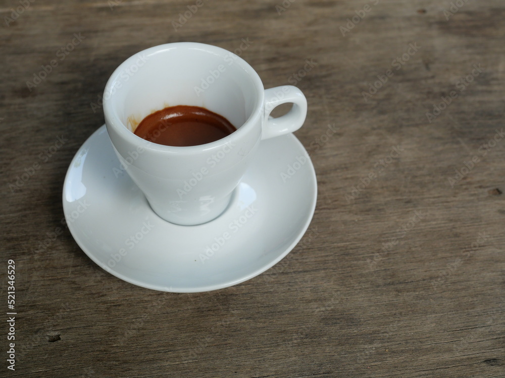 Espresso Coffee in white cup on brown wooden table , Hot drink on ceramic plate Espresso Coffee in white cup on brown wooden table , Hot drink on ceramic plate