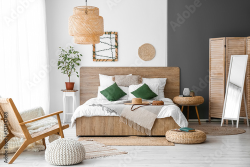 Interior of cozy bedroom with rattan poufs and mirror photo