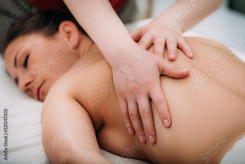 Back massage in a massage salon, woman having a relaxing back massage.