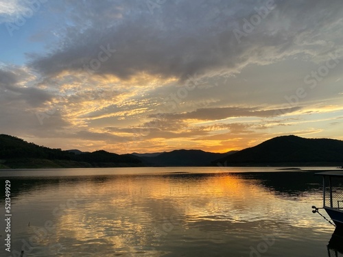 Mountains and sunset golden sky above dam reservoir