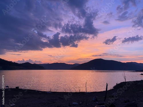 Mountains and sunset golden sky above dam reservoir