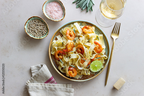 Pasta fettuccine in a creamy sauce with shrimp, lime and sage. Italian food.