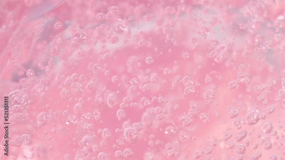 Macro pink transparent cosmetic serum gel, cream, fluid texture with air bubbles Macro pink transparent cosmetic serum gel, cream, fluid texture with air bubbles