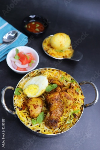 Chicken Biryani or murgh Pulao. Garnished with fried onion, mint leaves, and Boiled egg. Biryani is a famous Spicy nonvegetarian dish of India. Chicken cooked along with Basmati rice. Cucumber Raita.