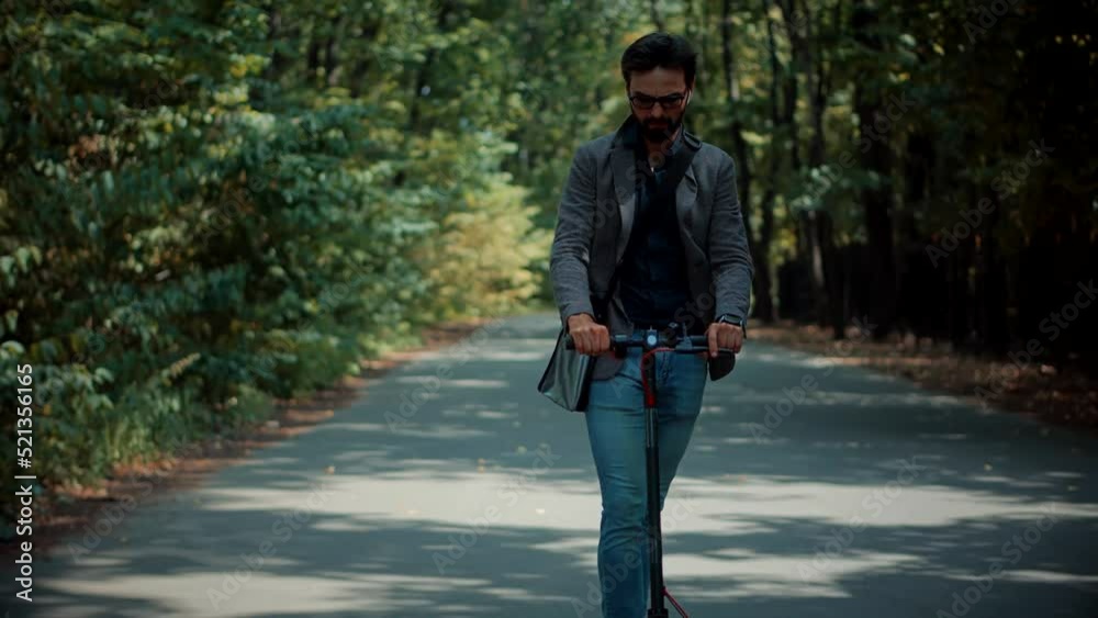 Driving Ecology Transportation. Man Ride Electric Scooter Mobility. E-Scooter Rider Rent Personal Eco Transport. Drive Electric Scooter In City. Urban Riding Ecological Transport Kick Electric Scooter