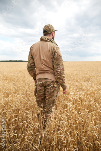 Ukrainian military man in wheat field. Ukrainian wheat fields and war upcoming food crisis. Armed Forces of Ukraine © leravalera89