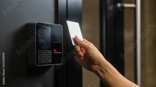 A woman opens the door with a plastic card. Modern keyless entry lock. 