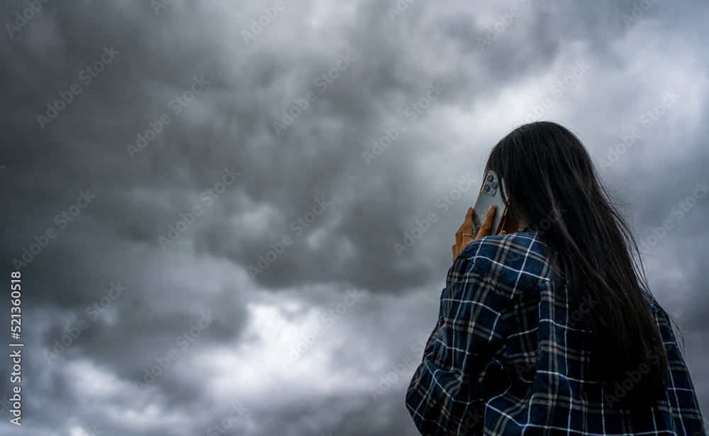 Beautiful asian woman with umbrella talking on the phone while raining and storm coming.Thunderstorm depression, Typhoon, Tornado.Dark cloud storm. Weather forecast outdoor . Beautiful asian woman with umbrella talking on the phone while raining and storm coming.Thunderstorm depression, Typhoon, Tornado.Dark cloud storm. Weather forecast outdoor .