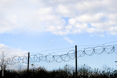 A fence with the barbed wire on it. Concept photo with copy space for any project.
