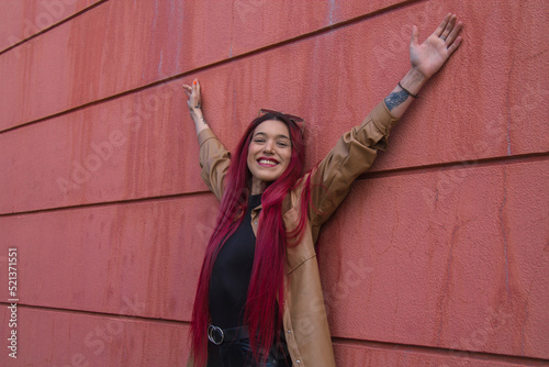 Φωτογραφία young hipster girl with urban posture on the wall