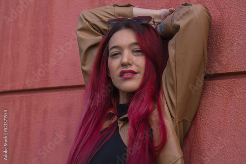 Photos young redhead hipster girl with urban pose on the wall