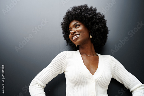 Fotobehang Fashionable young beautiful woman with afro hairstyle posing on the black wall