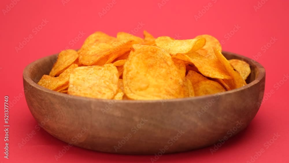 Hands of different people that take potatoes chips from wooden bowl Hands of different people that take potatoes chips from wooden bowl