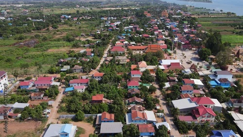 Drone footage above a rural village in Koh Okhna Tey island in Cambodia. Green fields and small houses along the Mekong river 1-2 photo