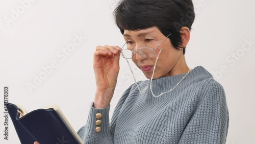 読書する老眼のシニア女性　白バック photo