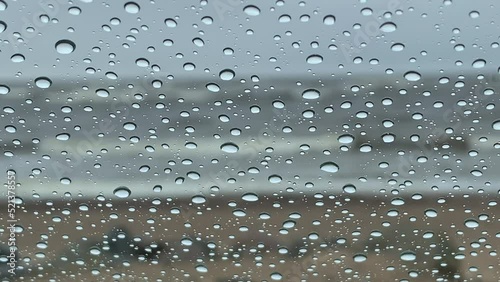 Wallpaper Mural Baltic sea waves during a spring storm seen through a window with raindrops close up. Bokeh blurry grey blue sea, huge white waves in far background Torontodigital.ca
