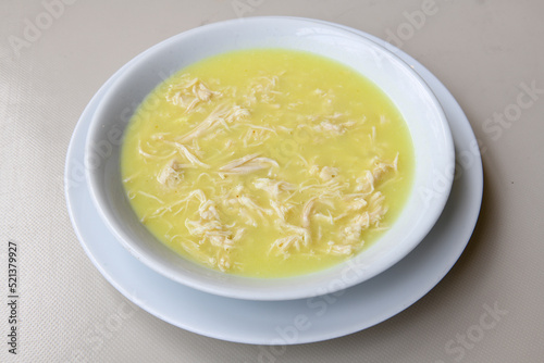 Homemade turkish soup Tavuk Suyu corbasi in a white ceramic soup plate.Turkish noodle chicken broth soup on a plate. Turkish meal (sehriyeli tavuk suyu corbasi) photo