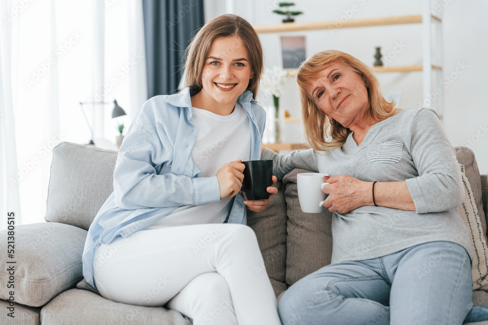Posing for a camera. Mother and daughter is together at home Posing for a camera. Mother and daughter is together at home
