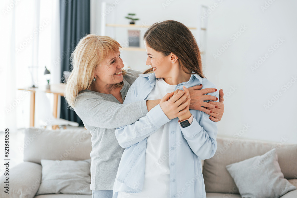 Fototapeta premium Posing for a camera. Mother and daughter is together at home