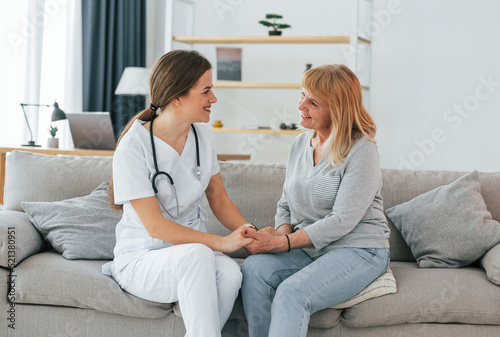 Senior woman have consultation by young female doctor indoors