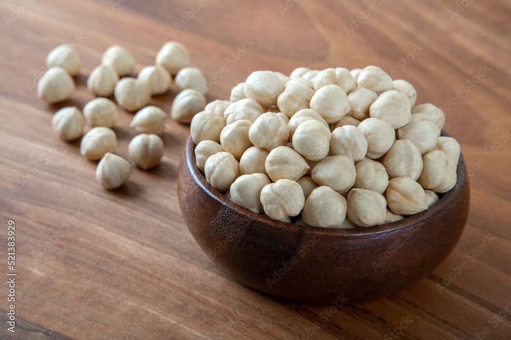 A bowl full of hazelnuts on wooden background A bowl full of hazelnuts on wooden background