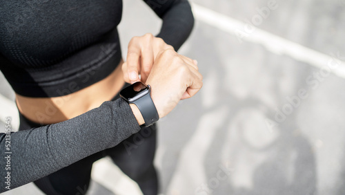 Uses a smart watch for sports and a cardio account app, a female runner does fitness running