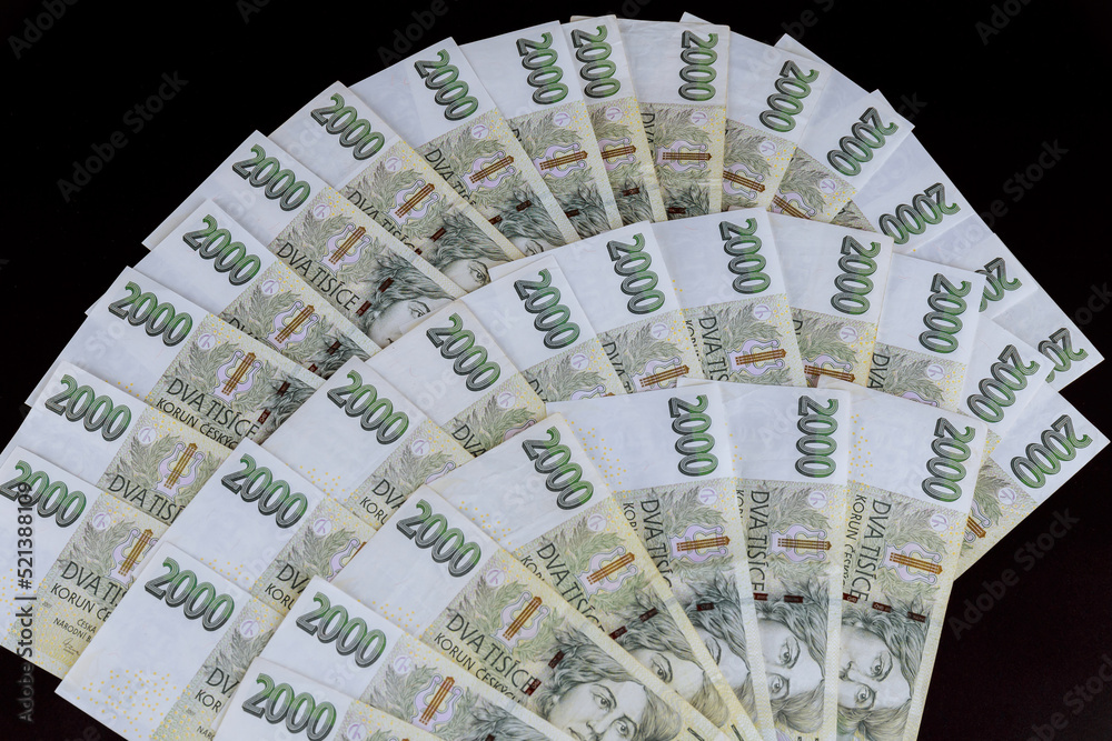 Czech crowns with a face value of two thousand. Lots of czech money on a black background. Czech crowns with a face value of two thousand. Lots of czech money on a black background.