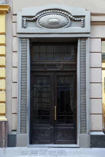 Entrance of house with beautiful door, elegant moldings and transom window