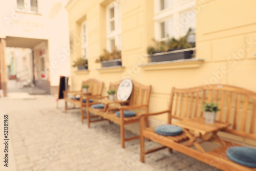 Blurred view of outdoor cafe with wooden benches
